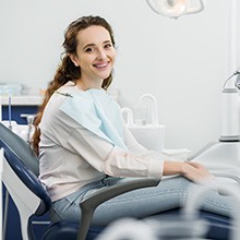 Woman sitting in dental chair and smiling