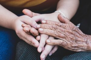 hands touch with elderly one on top 